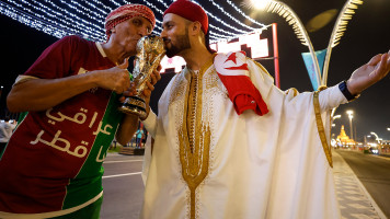 Supporters kiss a replica of the World Cup trophy ahead of the FIFA World Cup Qatar 2022