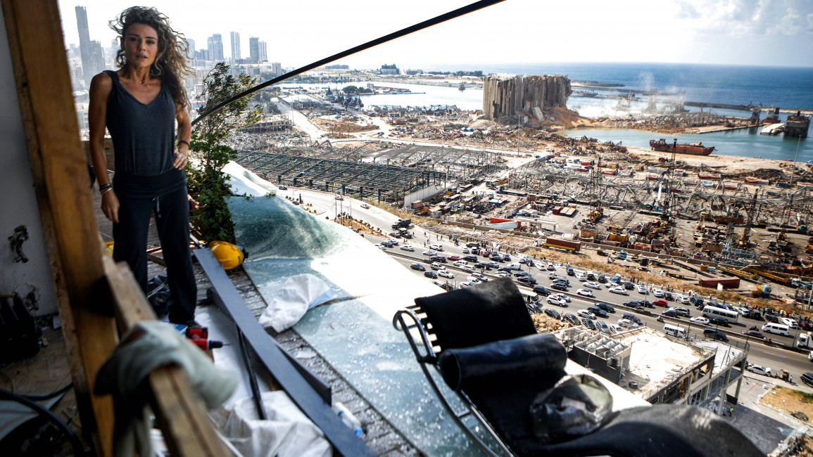 Karina Sukkar, a Beirut resident, stands the balcony of her damaged apartment overlooking the ravaged port in the neighbourhood of Mar Mikhael on 9 August 2020. [Getty]