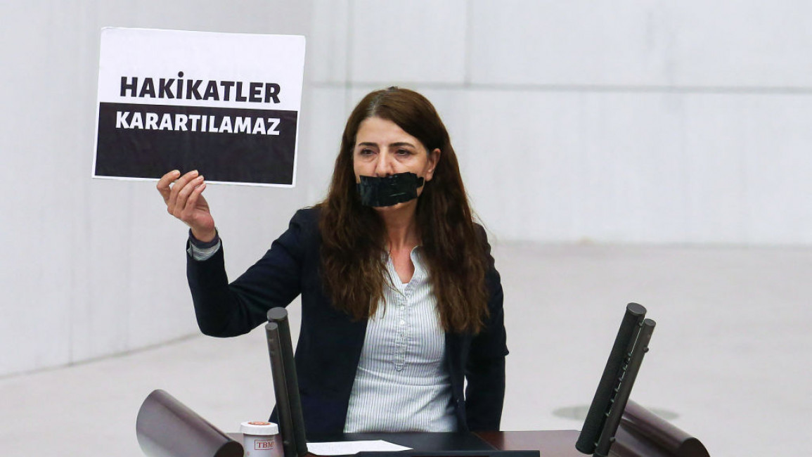 Turkish politician Zuleyha Gulum holds a sign reading 'Truths cannot be obscured' in parliament