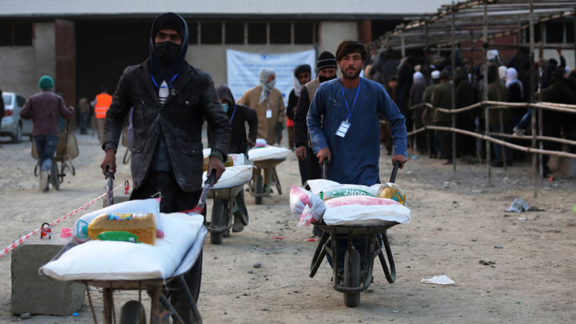 Men in Afghanistan pushing aid in wheelbarrows