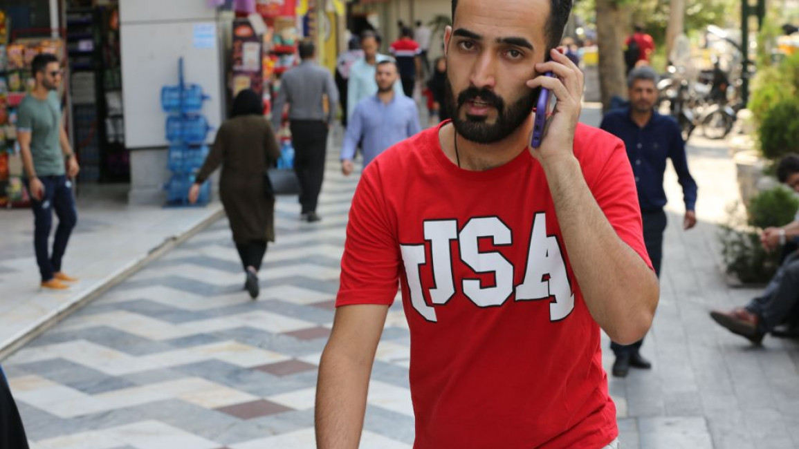 A man uses his mobile telephone at the Vali Asr square - AFP