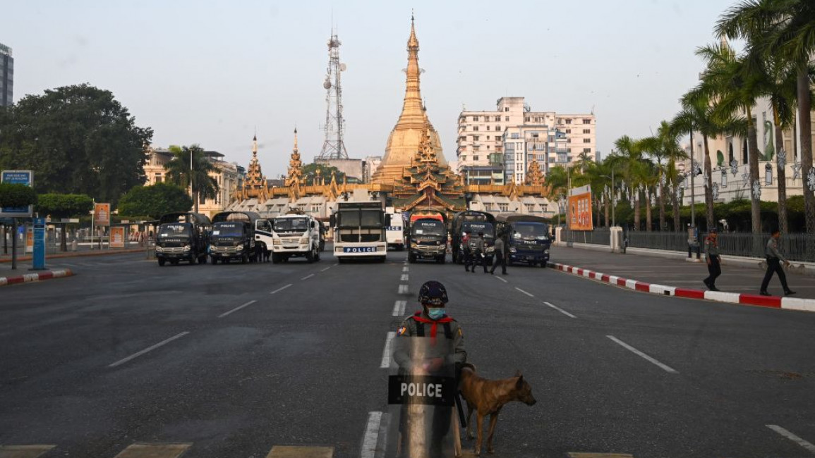 Police stand guard on a barricaded road outside the Yangon City Hall (R) and Sule Pagoda (C) in Yangon on 16 February, 2021. [Getty]