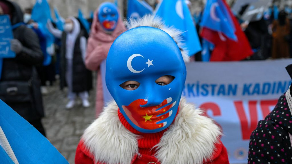 A child from the Uyghur community living in Turkey wears a mask during a protest against the visit of China's Foreign Minister to Turkey, in Istanbul on March 25, 2021. - Hundreds protested against the Chinese official visit and what they allege is oppression by the Chinese government to Muslim Uyghurs in the far-western Xinjiang province. (Photo by Bulent KILIC / AFP) (Photo by BULENT KILIC/AFP via Getty Images)