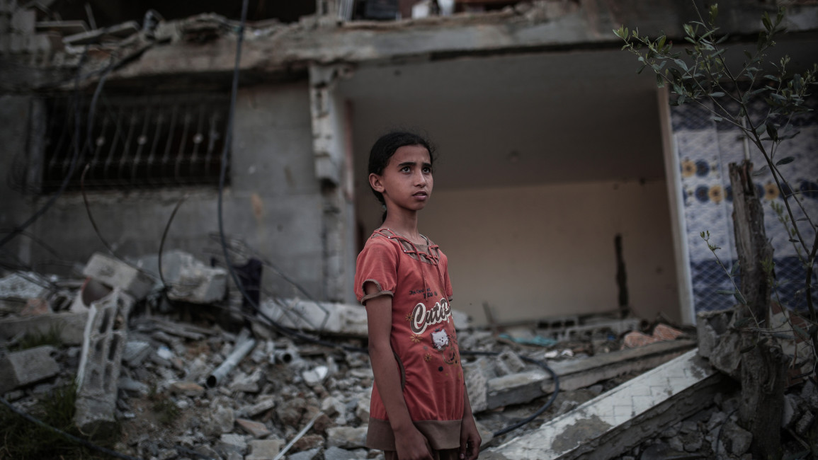 A child stands in front of a destroyed building targeted by Israeli attacks in Beit Hanoun, Gaza on 29 May 2021. [Getty]
