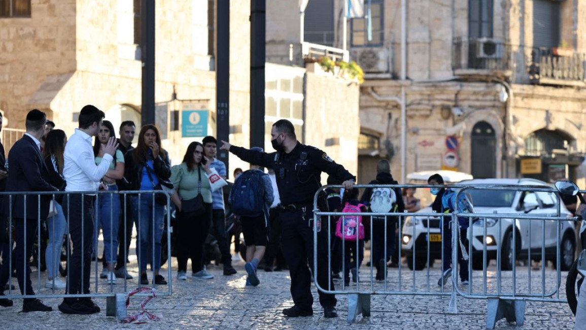 An Israeli police officer gestures outside the Al-Aqsa mosque after a woman