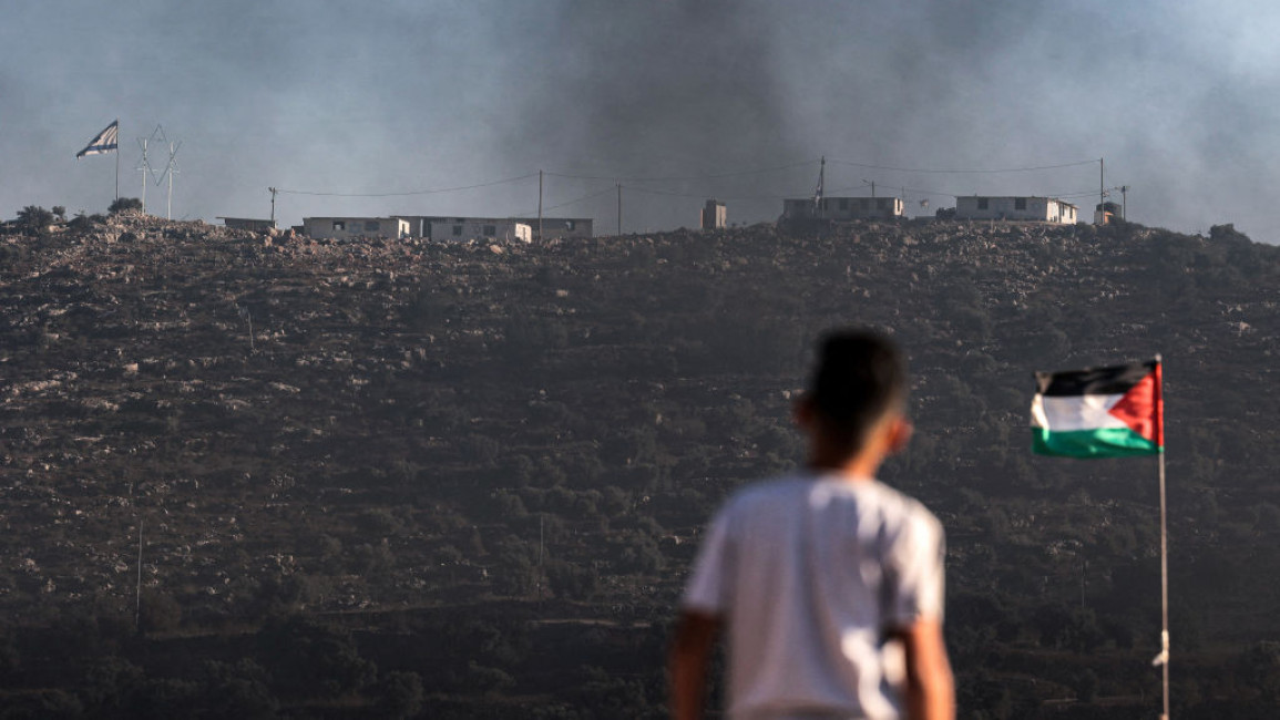 A Palestinian youth looks at the Eviatar settlement