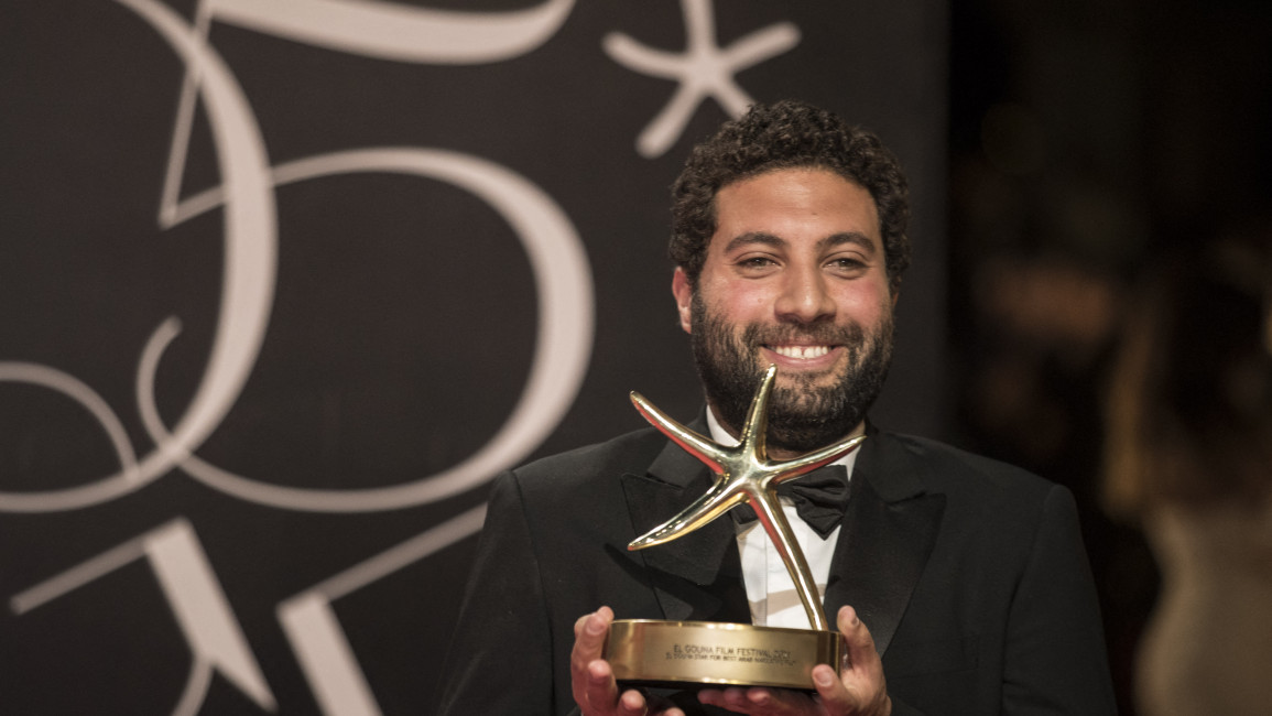 Egyptian film director Omar El Zohairy poses with his award poses with his award for the best Arab Narrative Film [Getty]