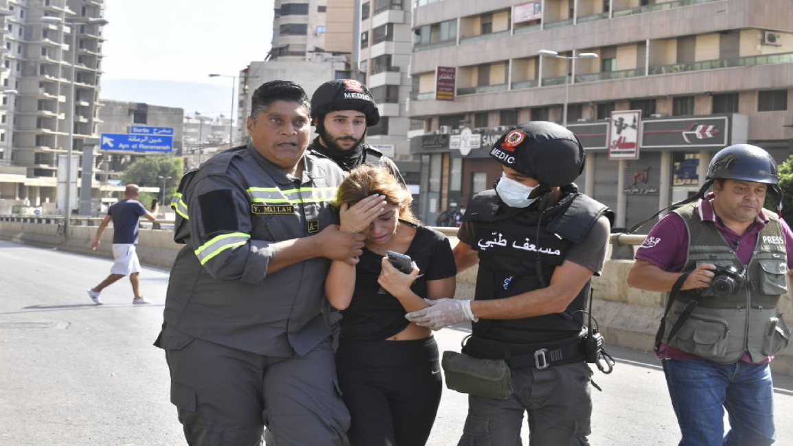 Medics and civil defense help a woman to safety in Beirut clashes