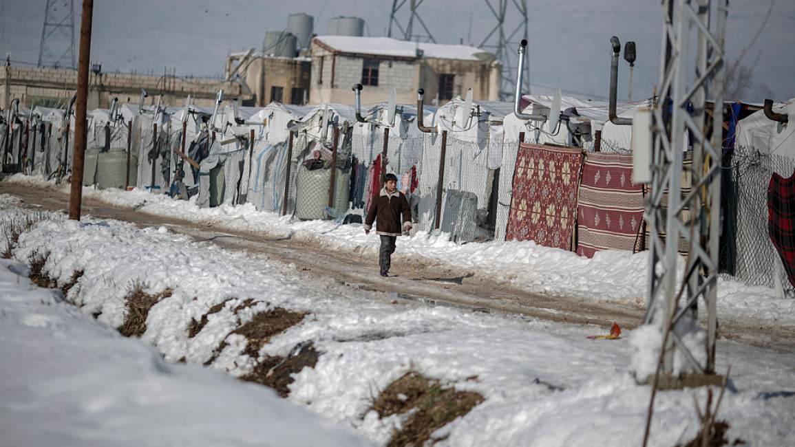 A Syrian walks in the snow at a refugee settlement in the Bekaa Valley