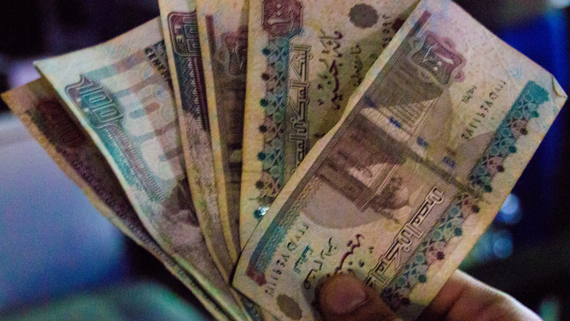 Egyptian banknotes being held in a person's hand