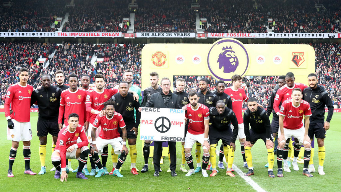 Both teams pose behind a sign reading Peace in several languages ahead of the Premier League match