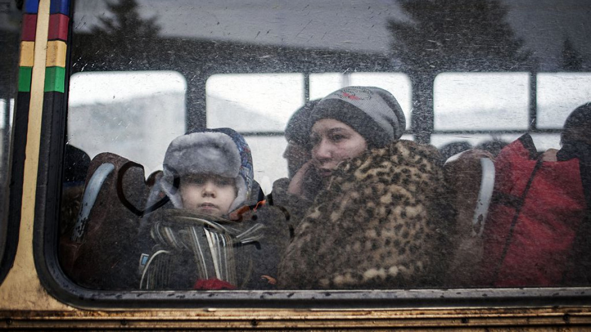 A displaced woman and a young boy sit in a bus before fleeing the Ukrainian city of Debaltseve