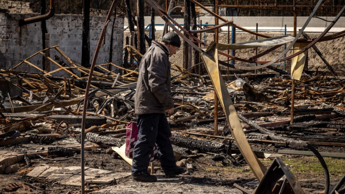 A man walks through the debris in a Ukrainian village amid the Russian invasion