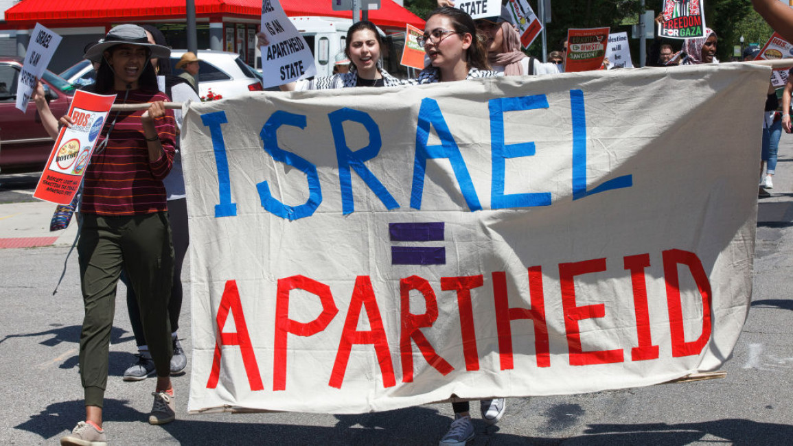 Protesters holding a banner that reads: "Israel = apartheid."