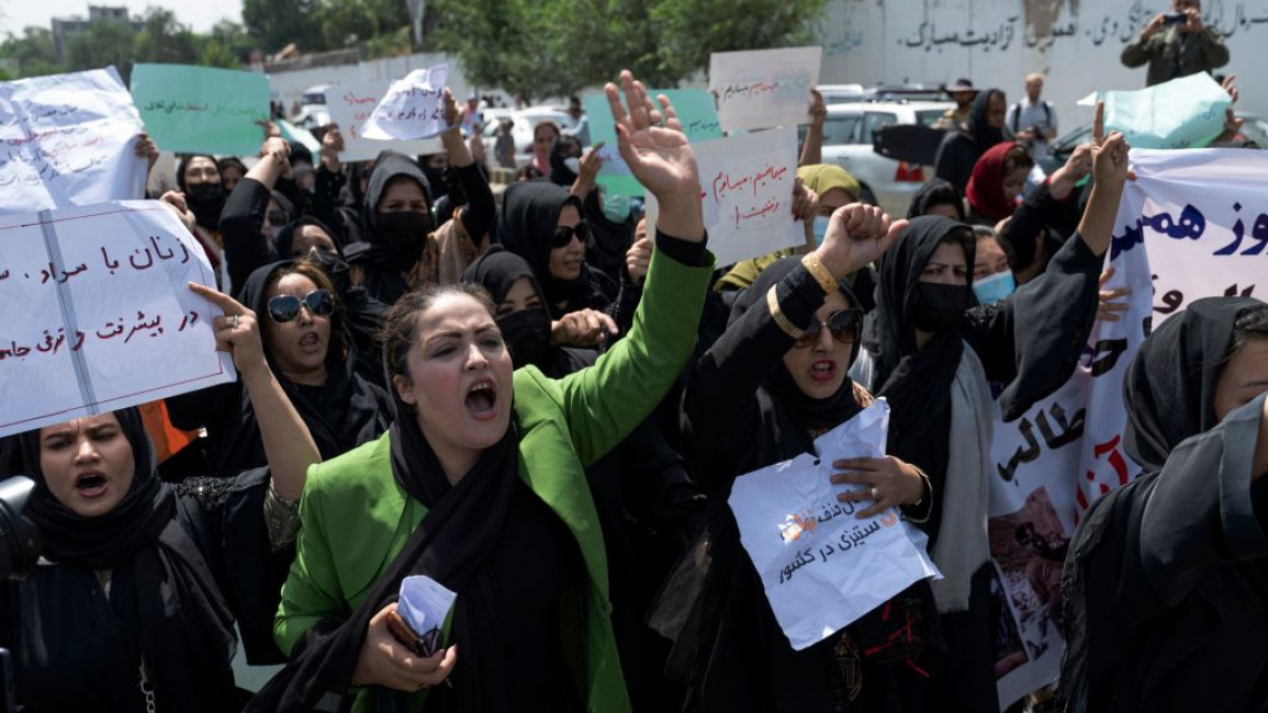 Afghan women hold placards as they march and shout slogans "Bread, work, freedom" during a womens' rights protest in Kabul on August 13, 2022 [Getty Images]