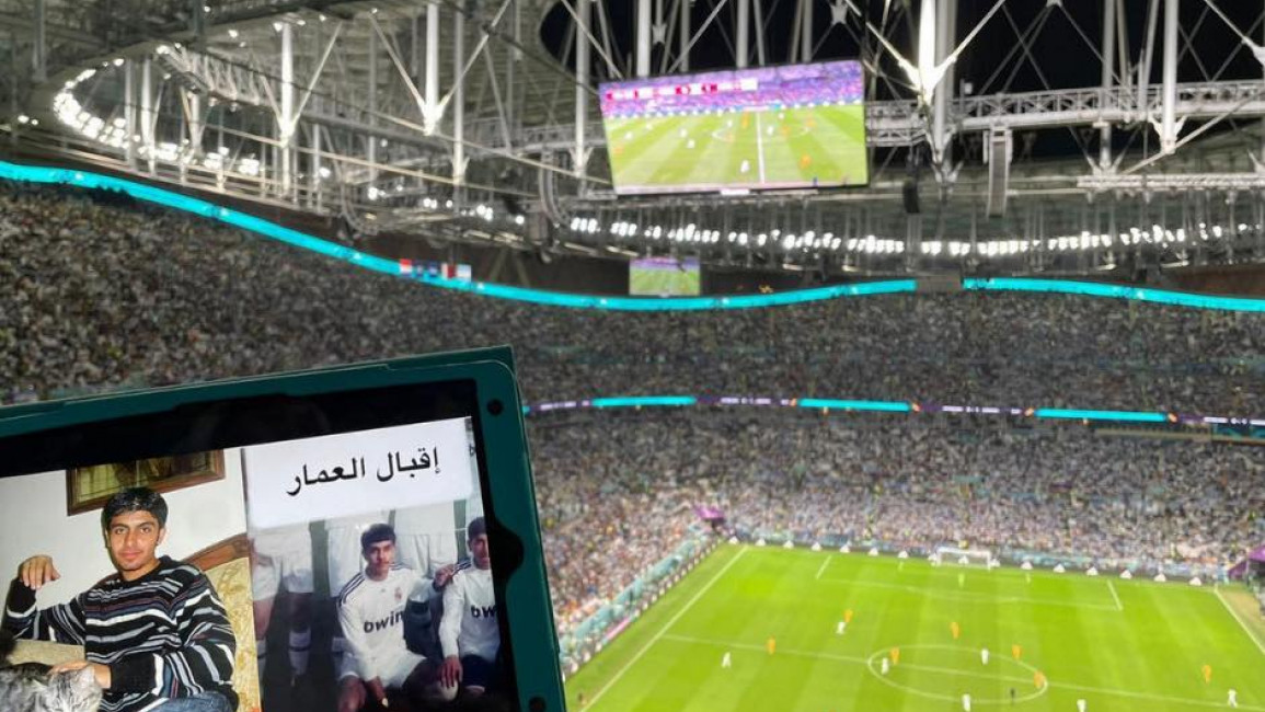 A picture of Iqbal, a Syrian detainee, is held up in front of a World Cup match in Doha. [Provided with permission by Families for Freedom].