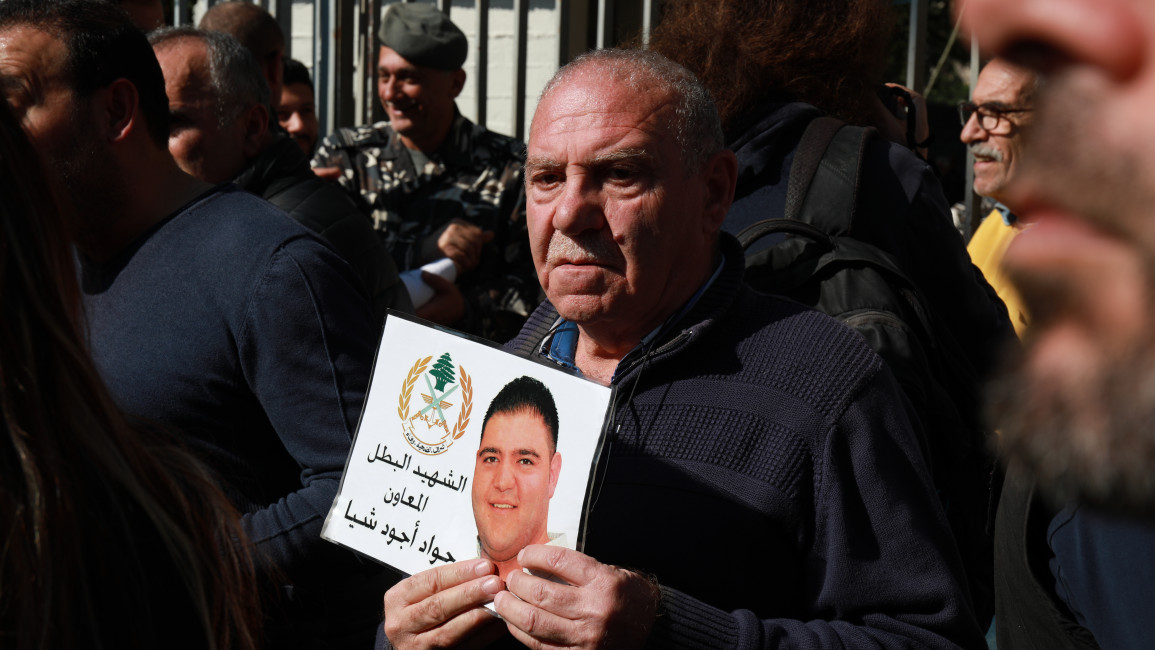 A protester holds up a picture of Batal al-Adwan, killed in the 2020 Beirut port blast, while protesting the targeting of Judge Tarek al-Bitar by Lebanon's public prosecutor. [William Christou - TNA] 