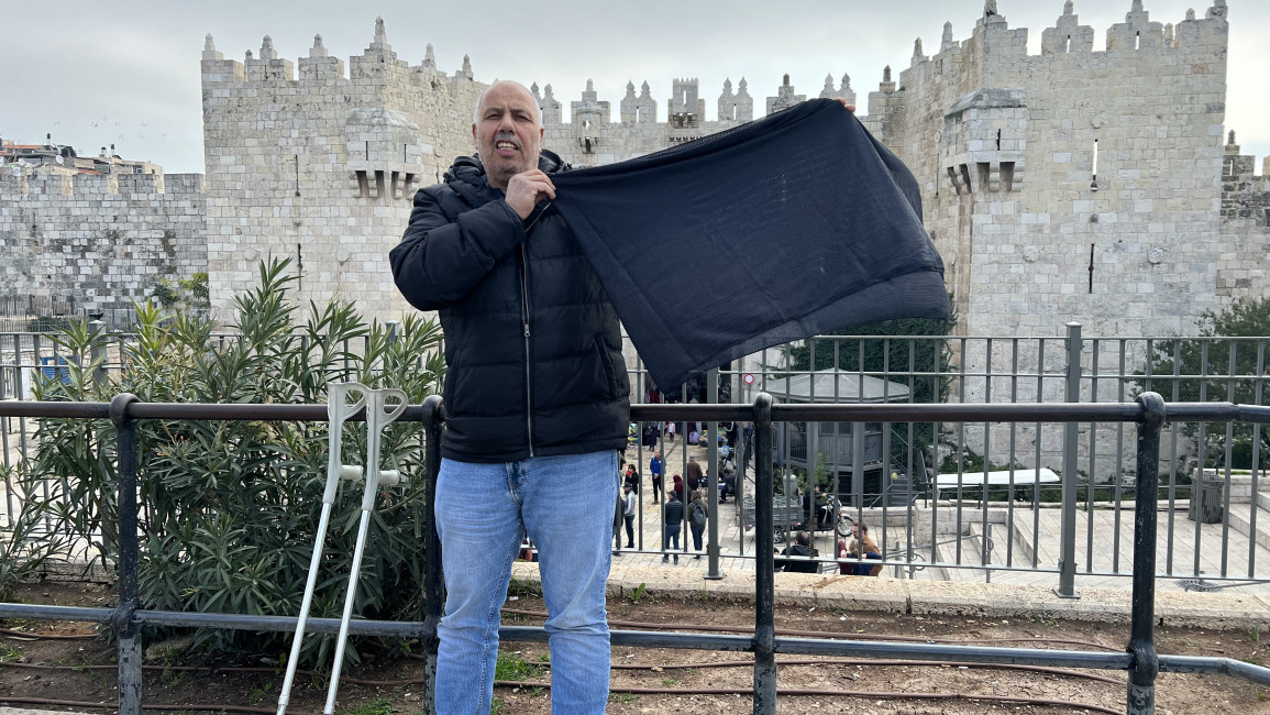 Palestinian activist waves a black cloth calling Ben Gvir's visit to the al-Aqsa a dark day