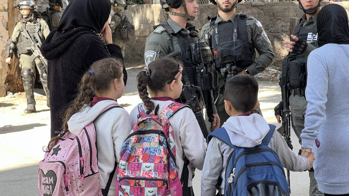 Palestinian children and teachers trying to navigate inside the refugee camp as the Israeli army demolished the Tamimi home, 25 January 2023. [Ibrahim Husseini/TNA]