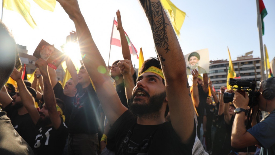 Supporters of Hezbollah leader Nasrallah watch as he makes his speech