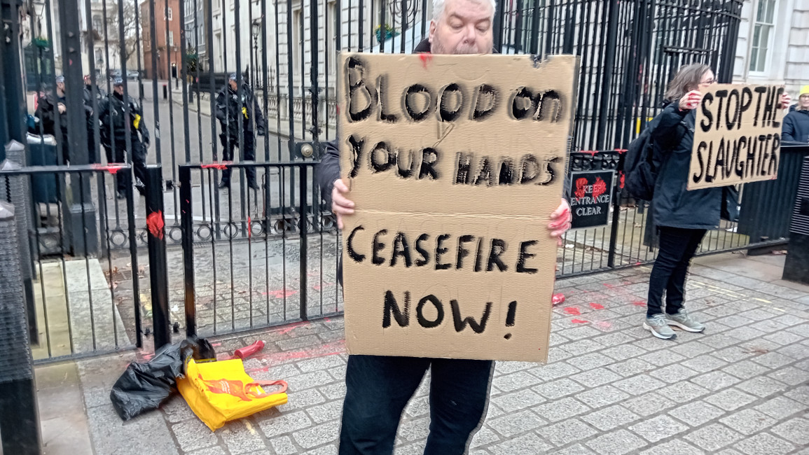 Man holds placard outside Downing Street 