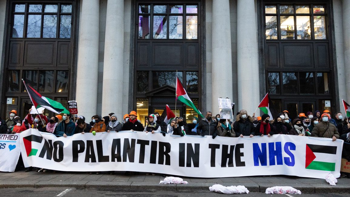Protesters hold a banner reading: 'No Palantir in the NHS'