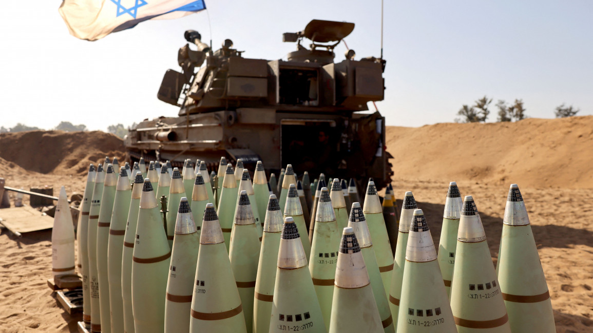 Artillery shells are placed next to an Israeli self-propelled artillery Howitzer at a position near the border with the Gaza 
