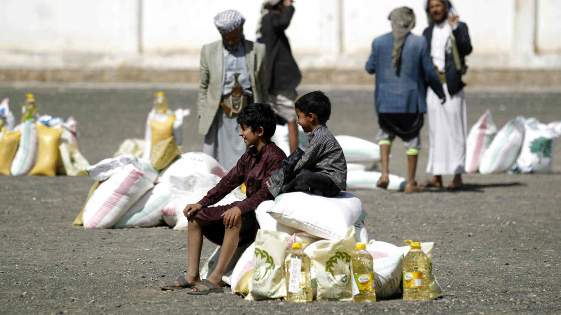 Yemeni boys sit atop food aid
