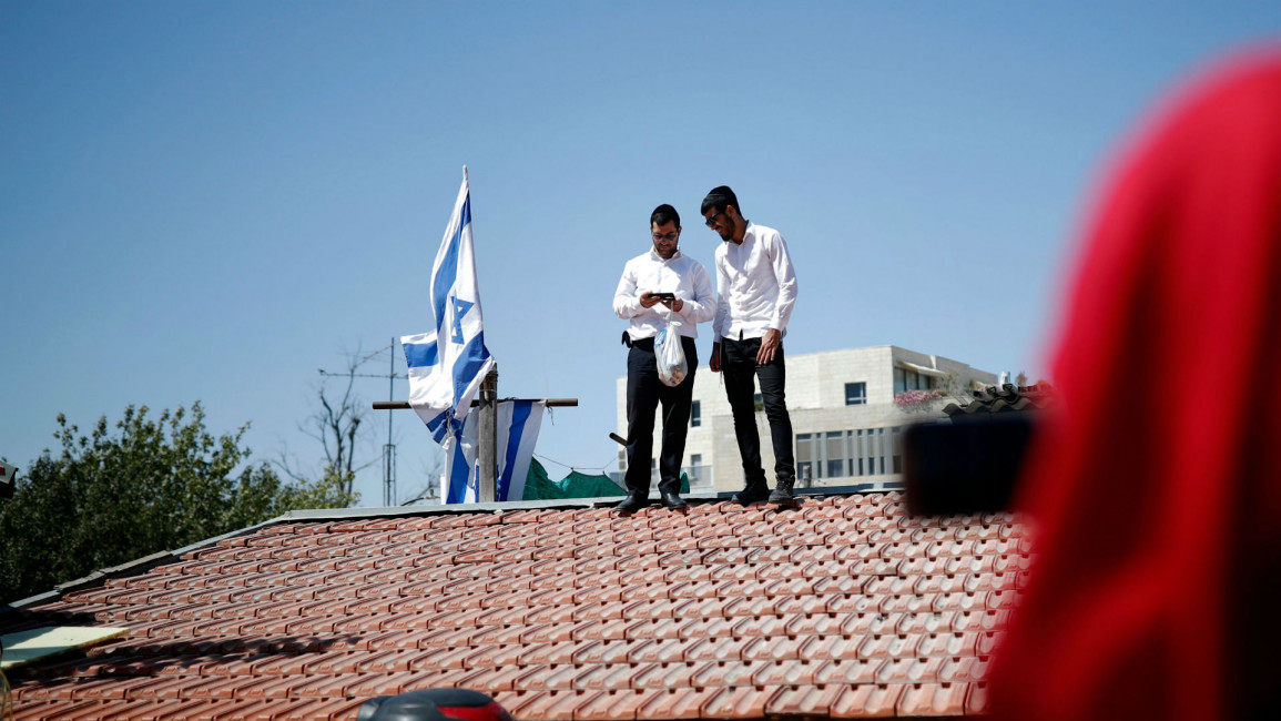 Israeli settlers raise Israel's flag outside Shamasna home [AFP]