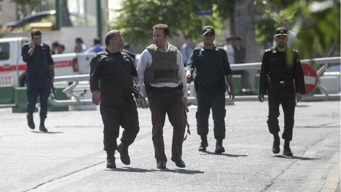 Police officers walk outside Iran's parliament building