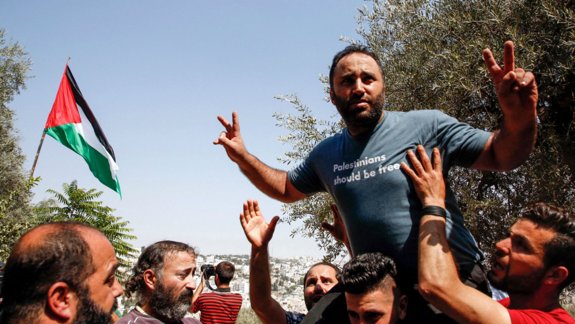 Issa Amro embraced by Palestinians after being released [AFP]