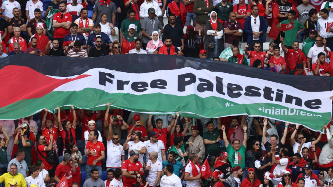 Fans hold a Flag of Palestine with Free Palestine written on it during the FIFA World Cup Qatar 2022 Group D match between Tunisia and Australia at Al Janoub Stadium