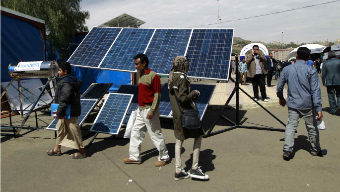Yemenis looking at solar panels at Sanaa university AFP